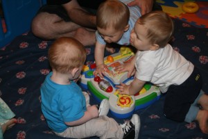 Dom (top left) and Alex (right) show Teddie their toys. (May 29, 2011)